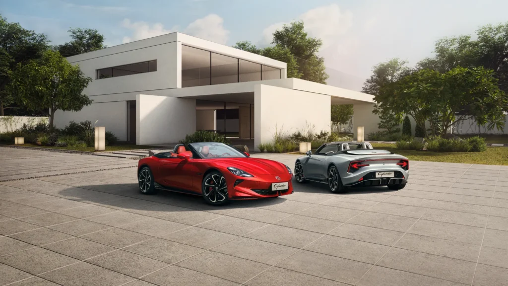 Til sportsbiler parkert utenfor et moderne, hvitt hus.