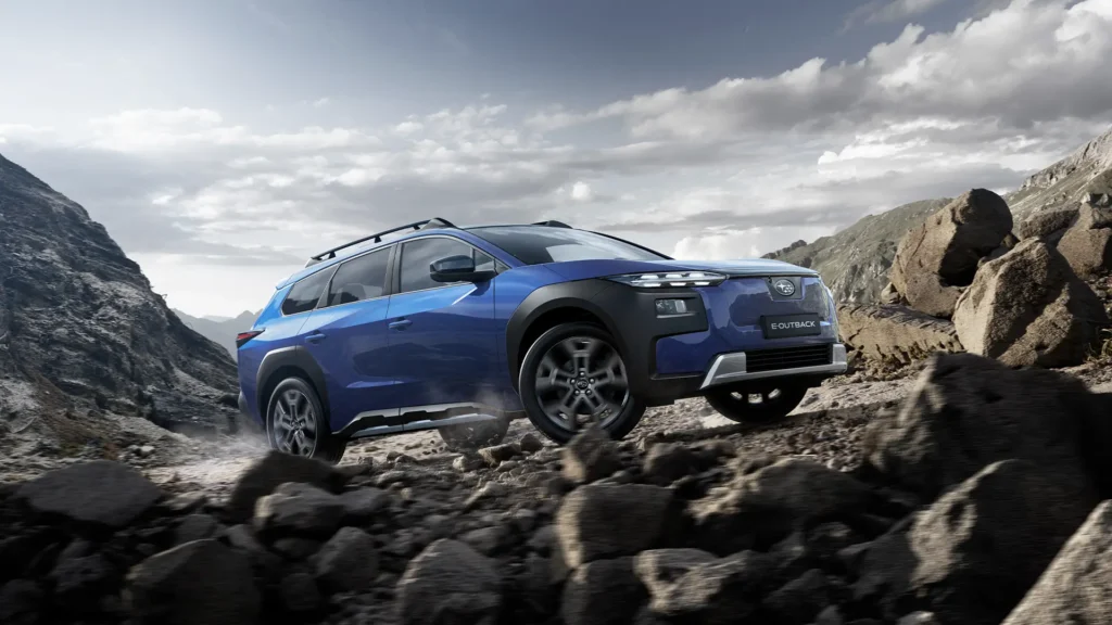 Blå Subaru E-Outback Wilderness kjører på steinete fjellterreng.