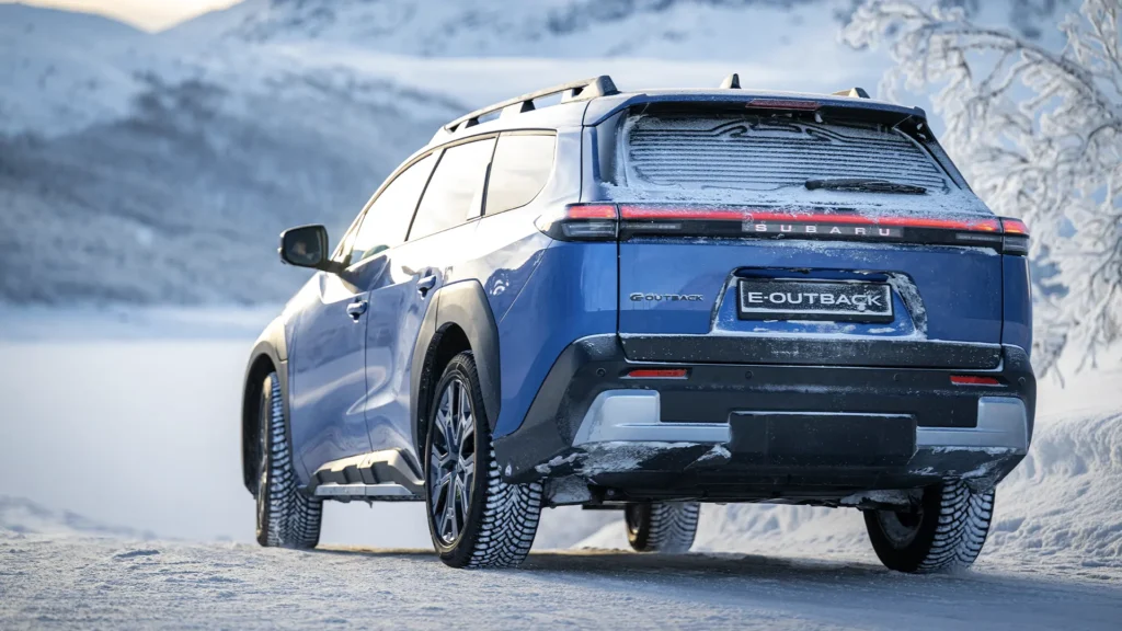 Blå Subaru E-Outback SUV parkert på snødekt vei.