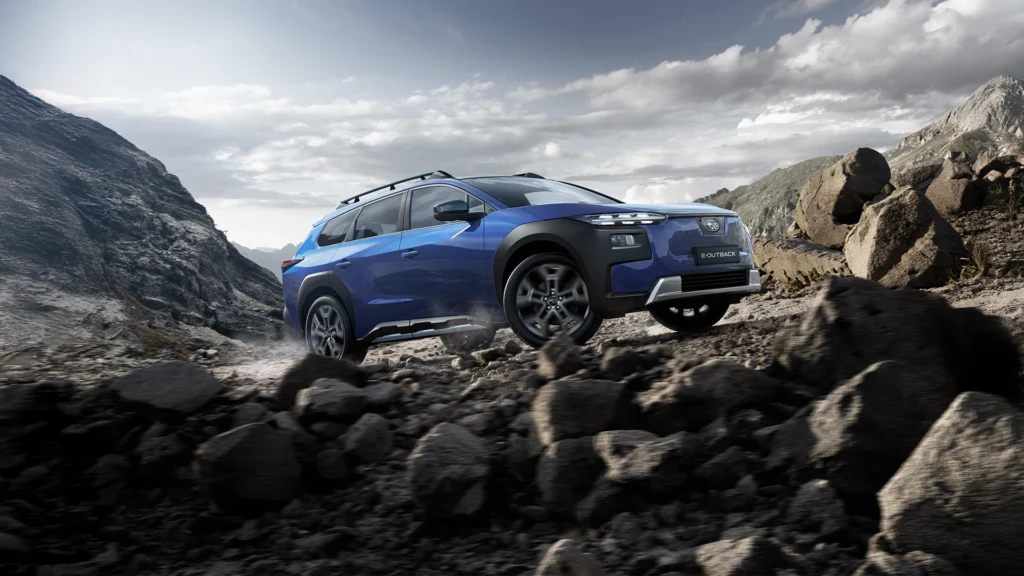 Blå Subaru E- Outback kjører i fjellandskap med steinete terreng.