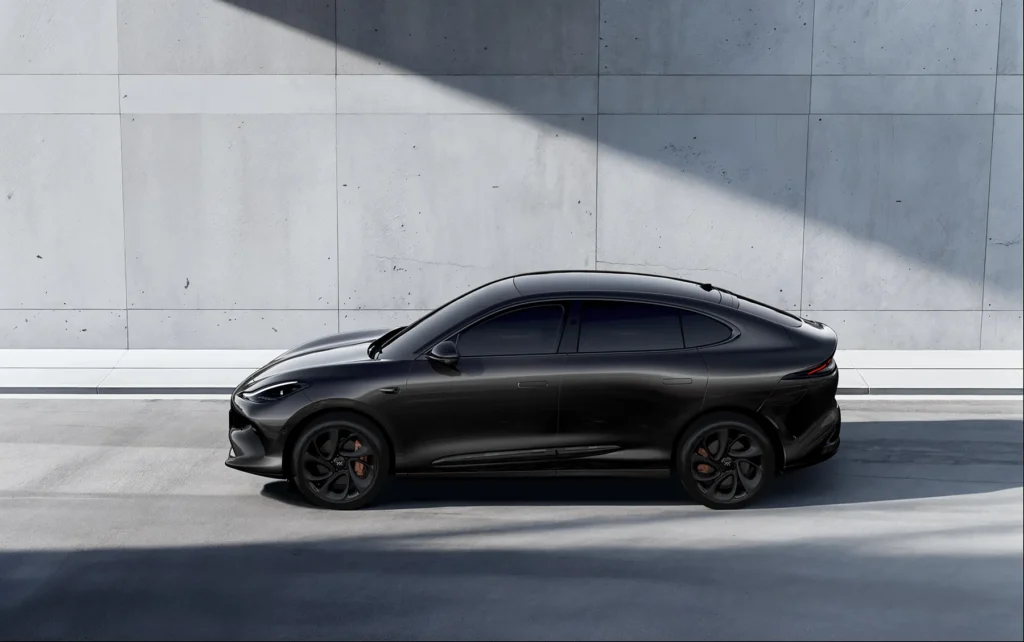 Svart MG IM6 sedan med sotede vinduer står mot lys grå vegg.