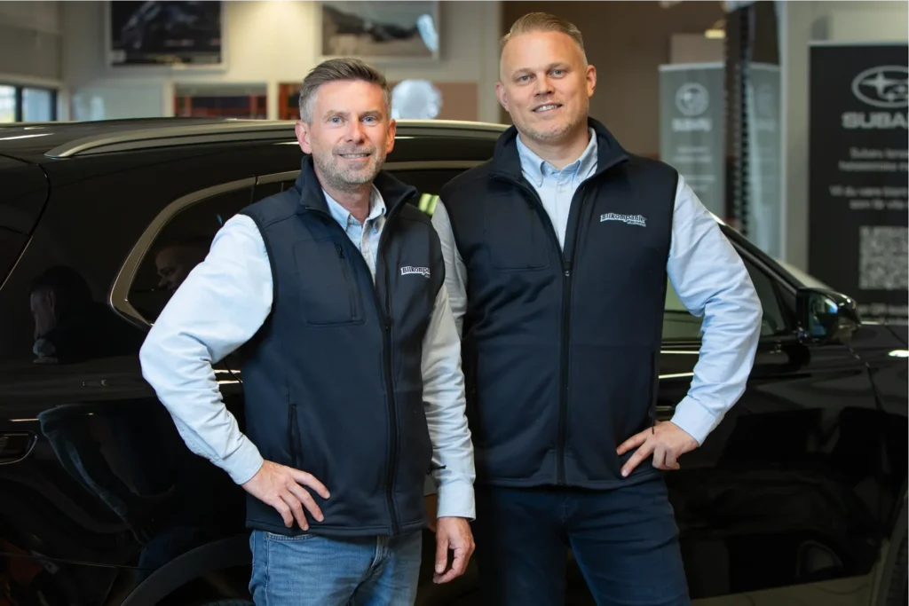 To menn ved svart bruktbil.