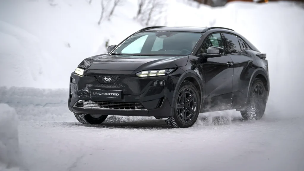 Svart Subaru SUV kjører på snødekt vei.