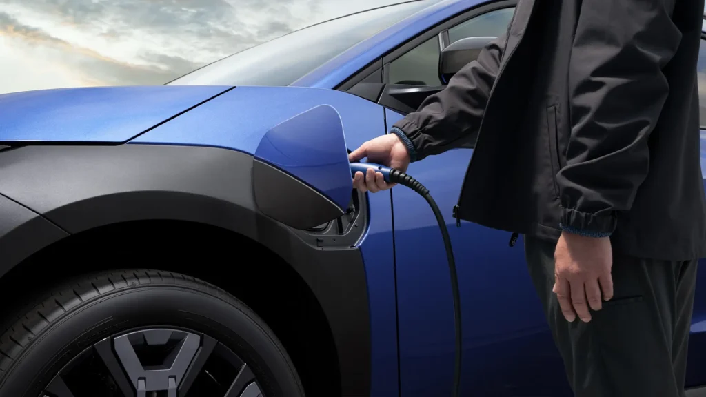 Person lader blå elbil.
